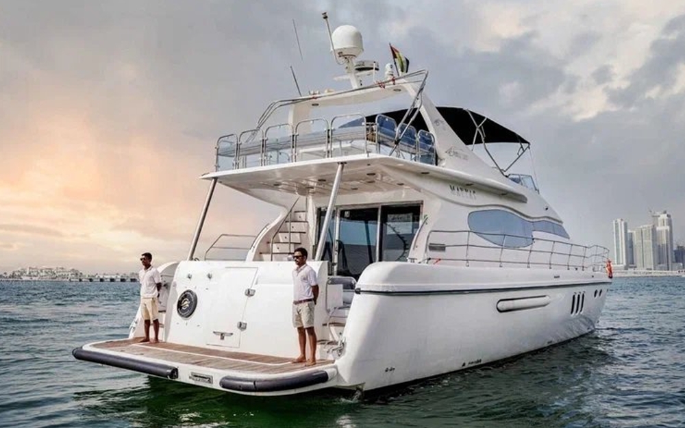 Rear view of 75 FT Mayyas yacht with crew onboard in Dubai waters